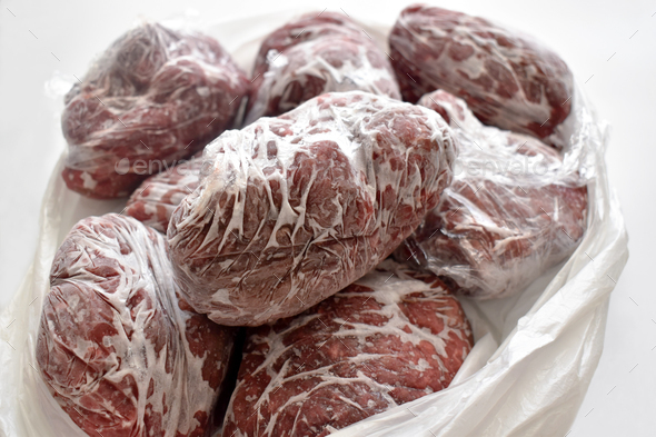 Frozen minced beef in food plastic wrap or cling film in a plastic bag.