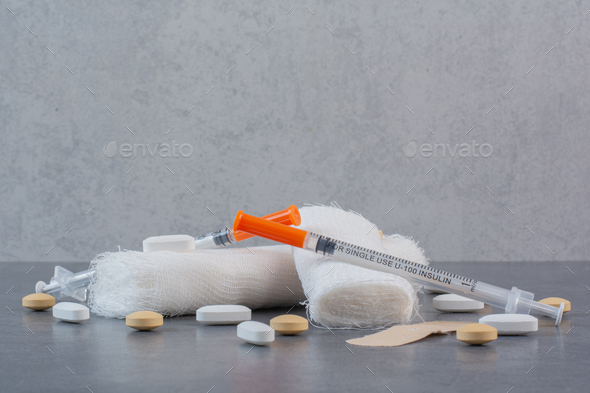 Band aid plaster strips, bandage and syringe on marble surface Stock Photo  by 13people