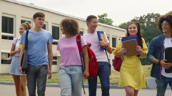 Slow Motion Cheerful Students Walking Against College Building alt