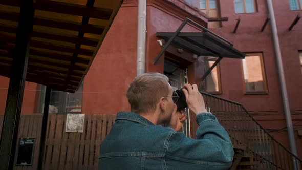 A Young Traveller Takes Pictures of a Red Brick Building in an Old Town alt