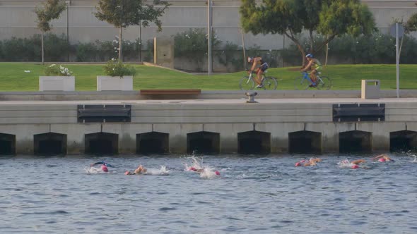 Triathletes Cycling and Swimming alt