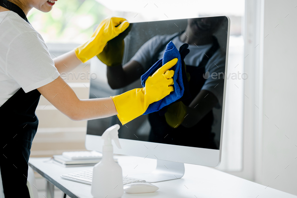Young woman using a computer cleaning cloth to disinfect the officeoffice cleaning staff cleaning ma
