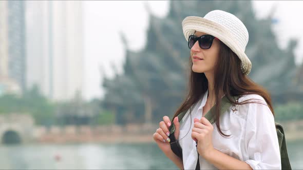 Young Woman Touirist Standing in Front of the Ancient Temple with Backpack alt