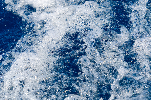 Abstract blue sea water with white waves. Blue sea texture with waves and foam. Mediterranean sea