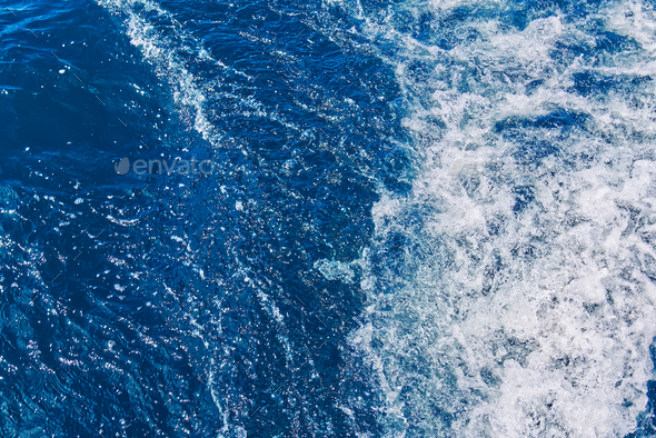 Abstract blue sea water with white waves. Blue sea texture with waves and foam. Mediterranean sea