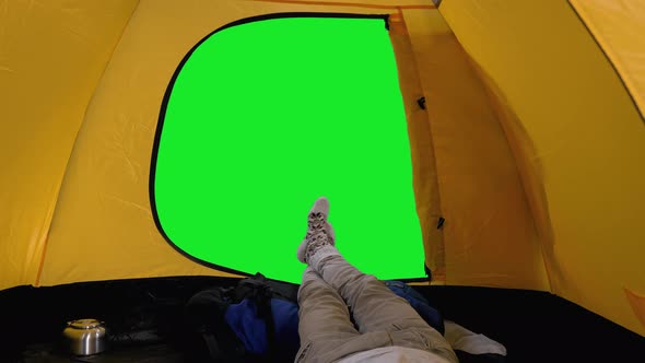 View of Camper Relaxing in Open Tent, Male Legs in Woolen Socks  Against Green Screen
