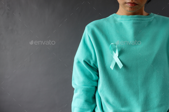 Teal ribbon on teal sweater support cervical cancer.