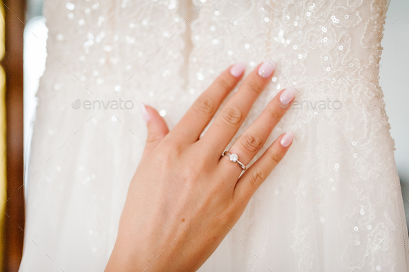 Close up of hands of woman showing elegant diamond ring on the finger, love and wedding concept.
