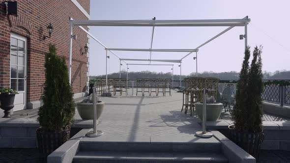 Wide Shot of Hotel Terrace in Sunshine with Chairs Standing Outdoors alt