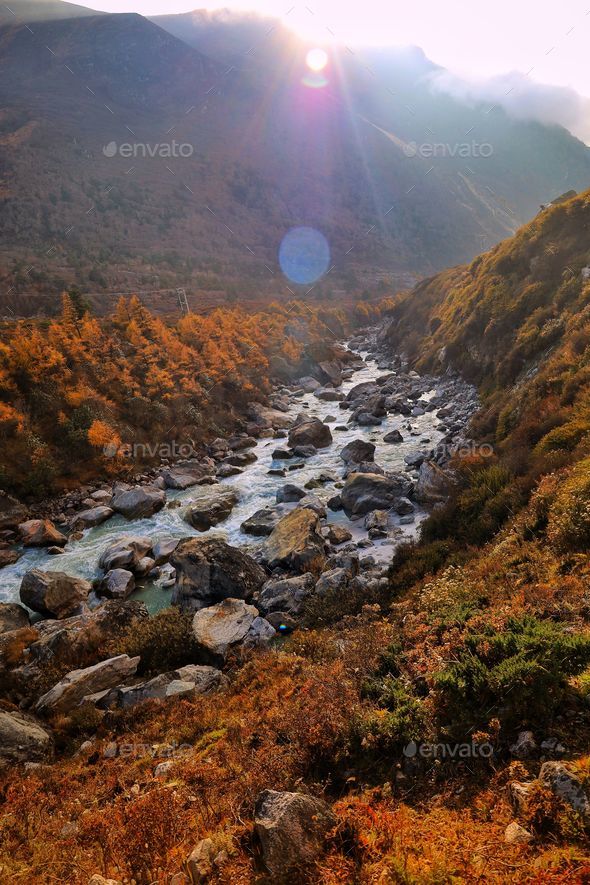 River surrounded by mountains and shrubs in the Himalayas, Nepal Stock