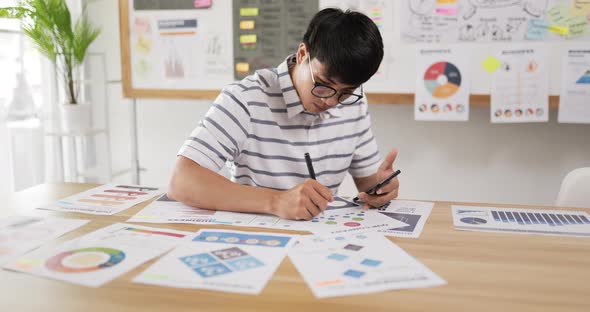 Asian man glasses checking to task alt