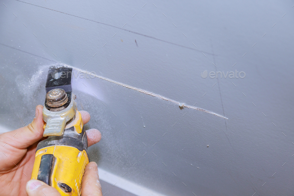 A multitool was used to cut plasterboard with a single blade to lay an electric cable in wall using