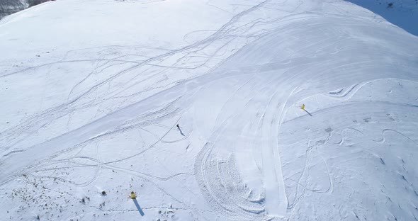 Aerial Follow Over Skier Alpine Skiing in Winter Snowy Mountain Ski Track Field in Sunny Day alt