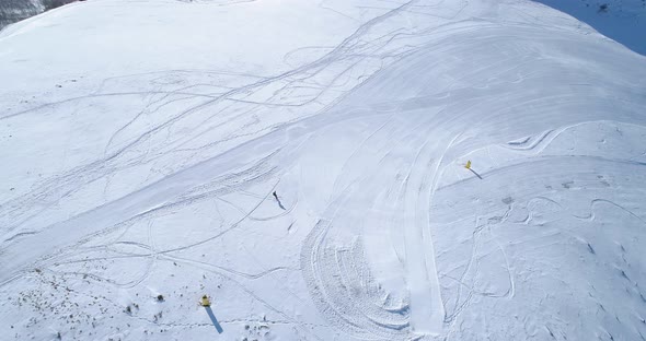 Aerial Follow Over Skier Alpine Skiing in Winter Snowy Mountain Ski Track Field in Sunny Day