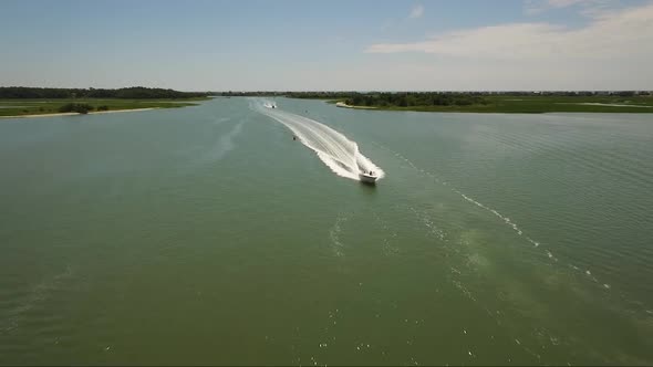 Flying over boats in the IntraCoastal Waterway during middle of the day in the summer on a sunny day alt