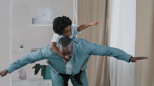 Mature African American Grandpa Plays with Little Granddaughter Joyful Kid Pretends to Be Flying on alt