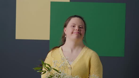Portrait of Happy Girl with Down Syndrome Holding Flower Bouquet alt