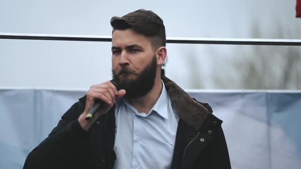 Annoyed Spokesman Guy on Stage with Mic Gives Speech and Address Riot Activism alt