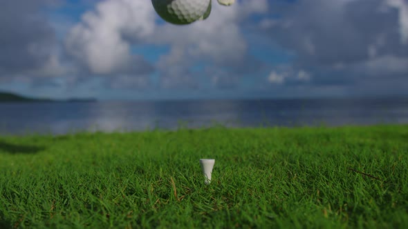 Male Hand in a Golf Glove Puts the Ball on the Field on the Background of the Blue Ocean alt