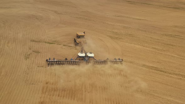 Shooting From a Drone. A Tractor Is Cultivating the Land.  alt
