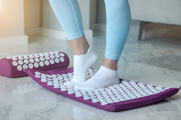 Acupressure mat massage therapy. Woman feet standing on acupressure mat for self health massage