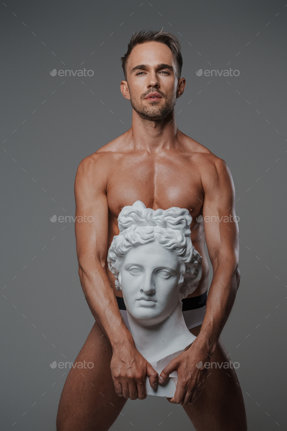 Handsome Young Toned Muscular Man In Underwear Pose On Grey Wall