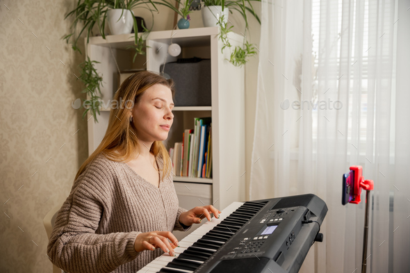 Woman learns to play the piano with a teacher online