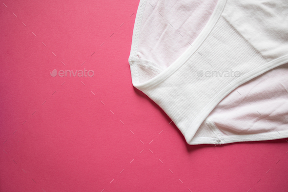 On a pink background, a detail of gusset panties, women's white panties  Stock Photo by sweet_elenia
