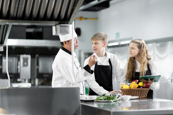 Students are learning to cook in a culinary institute with a standard kitchen