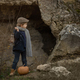 a boy in vintage clothes  with an old kerosene lamp stands with a pumpkin - PhotoDune Item for Sale