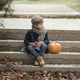 boy with no front teeth sitting with a pumpkin on the steps - PhotoDune Item for Sale