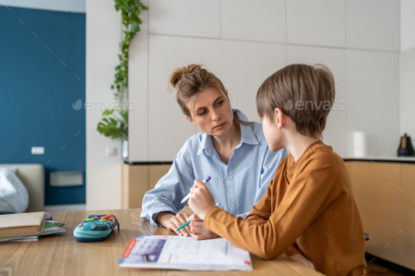 Young woman teacher tutor listening little boy pupil while giving private lesson