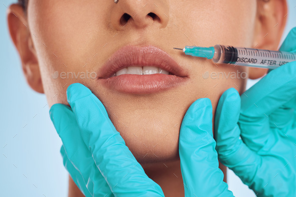 Closeup, woman and plastic surgery with a needle, lip filler and cosmetics against a blue studio ba