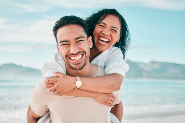 Lovely gay couple on piggyback ride at the beach. Stock Photo