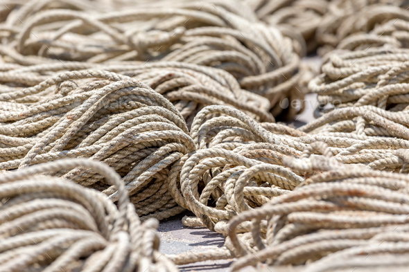 Old heavy duty rope laying outside on the asphalt, closeup