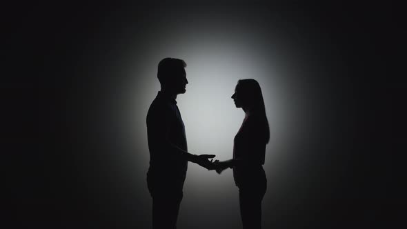 man and woman holding hands silhouette