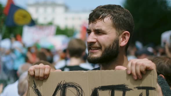 Face Portrait of Man on Opposition Political Rally with Placard Banner Shouts