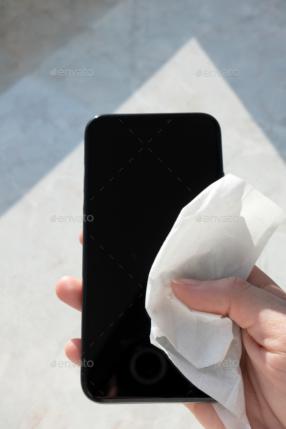 Hand holding smartphone and cleaning antiseptic wipes for mobile phone