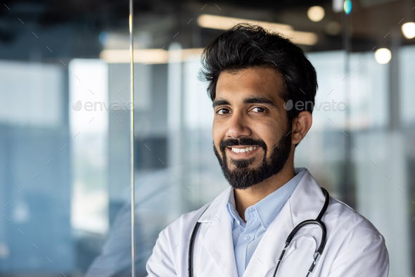 Close-up photo. Portrait of a young Indian male medical student, intern. Standing smiling and