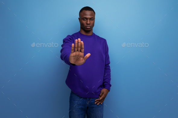 serious young african guy in a blue sweatshirt asks to stop