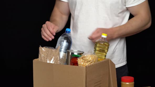 Volunteer Putting Food in a Donation Box. Charity Concept alt