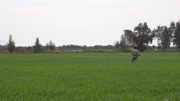 A Farmer Dispersing and Sprinkling Seeds Across His Agricultural Field With His Hand alt