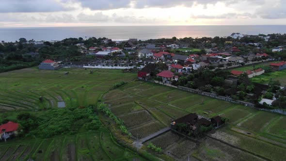 Aerial View over Bali Rice Fields Flying Towards the Ocean at Sunset alt