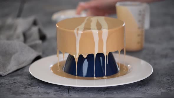 Woman Pastry Chef Hands Pours Mirror Glaze on Frozen Cake