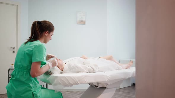 Female Beautician Makes Face Rejuvenation and Cleansing Procedure for Girl alt