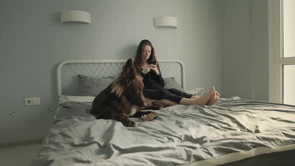 Woman With Her Dog In Her Bed alt