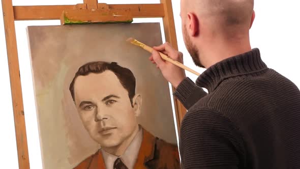 Talanted Painter Paints a Picture of Man By Oil Paint Brush with Palette in His Hand, on Easel alt