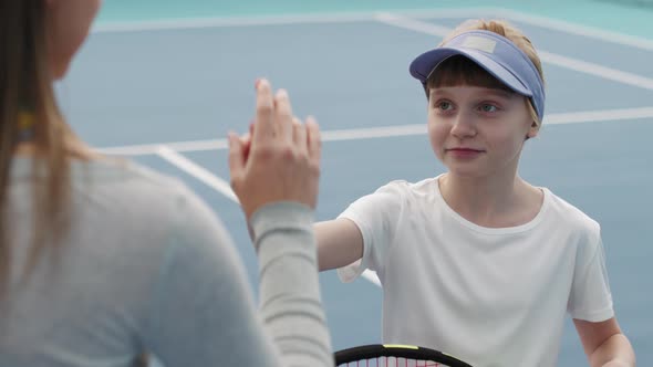 Tennis Coach And Little Girl Giving High Five alt