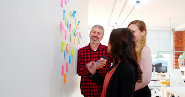 Executives discussing over sticky notes alt