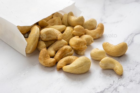 Many cashew nuts on marble background.